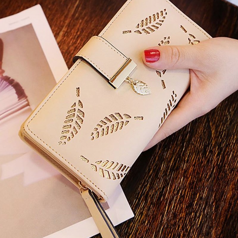 Model holding the Gold Leaf Print Pattern Wallet in khaki and gold.