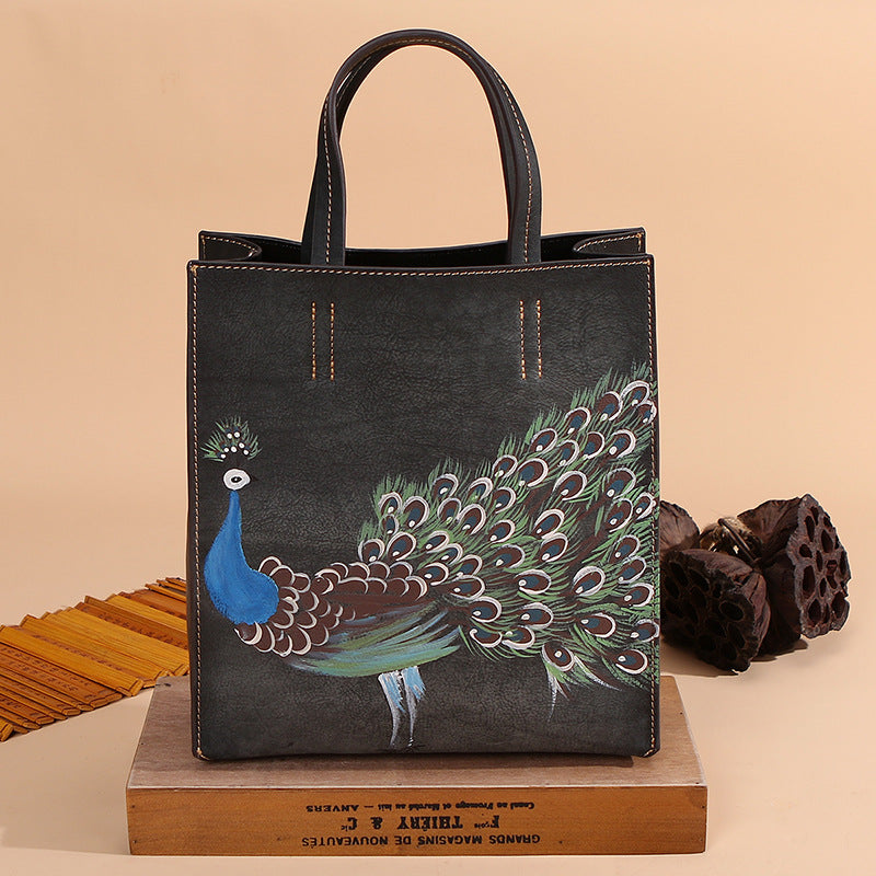 Vintage Leather Peacock Handbag positioned on top of a flat wooden box in black.