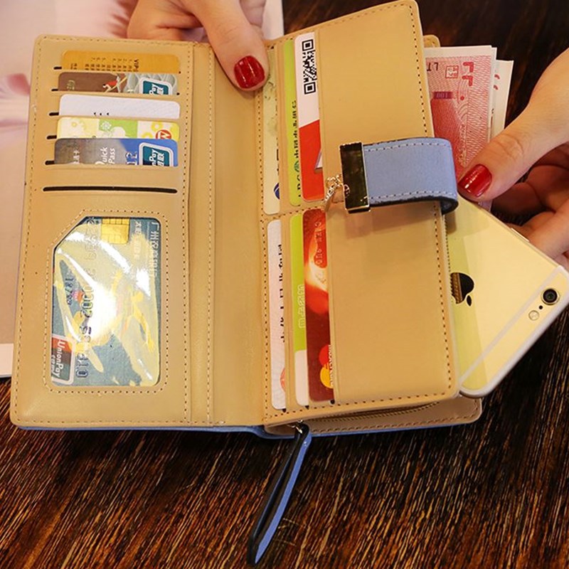 Opened view of model  holding the Gold Leaf Print Pattern Wallet  in both hands.