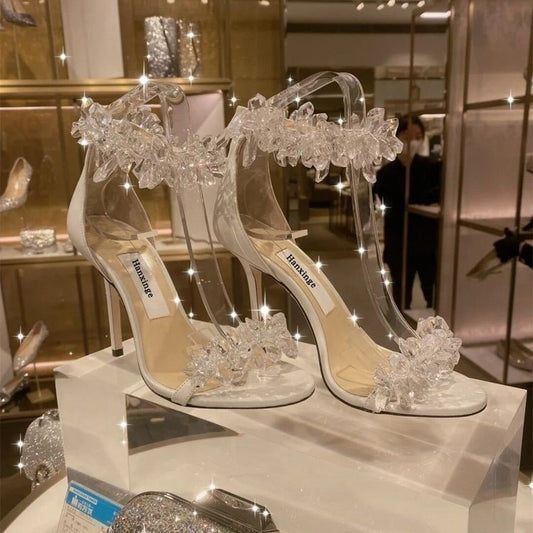 Pair of Crystal Rhinestone Flower High Heels displayed on a shoe stand in a store.
