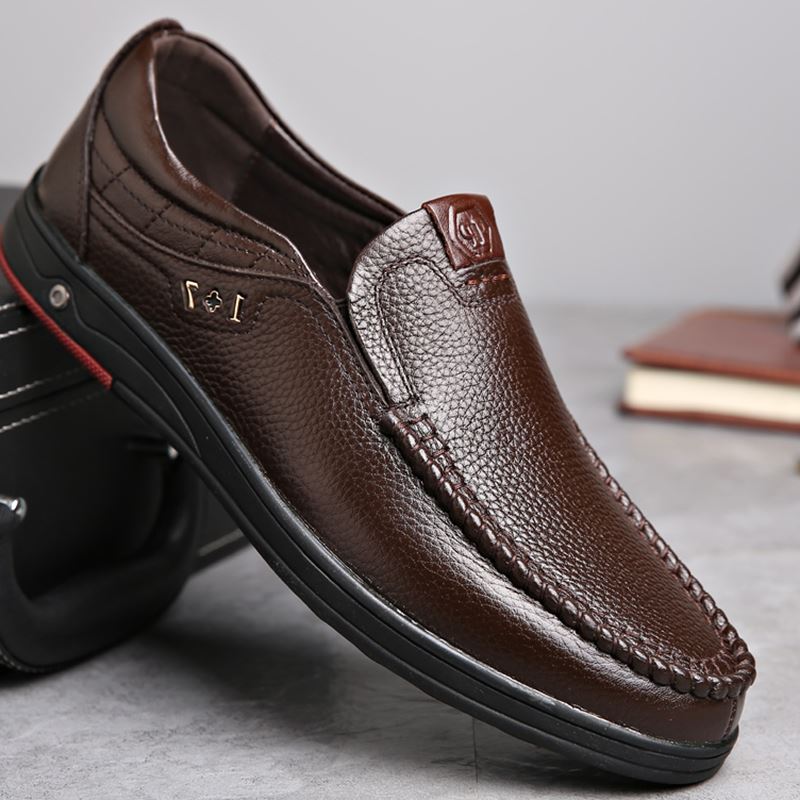 Business Casual Leather Loafers in brown positioned against a briefcase.
