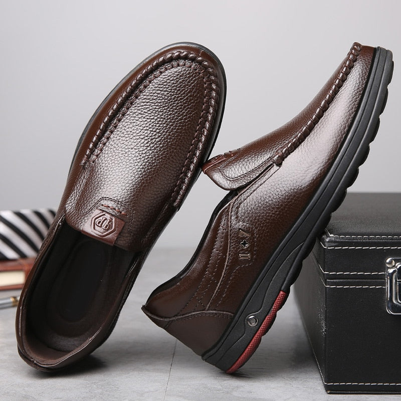 Business Casual Leather Loafers in brown positioned against a briefcase.